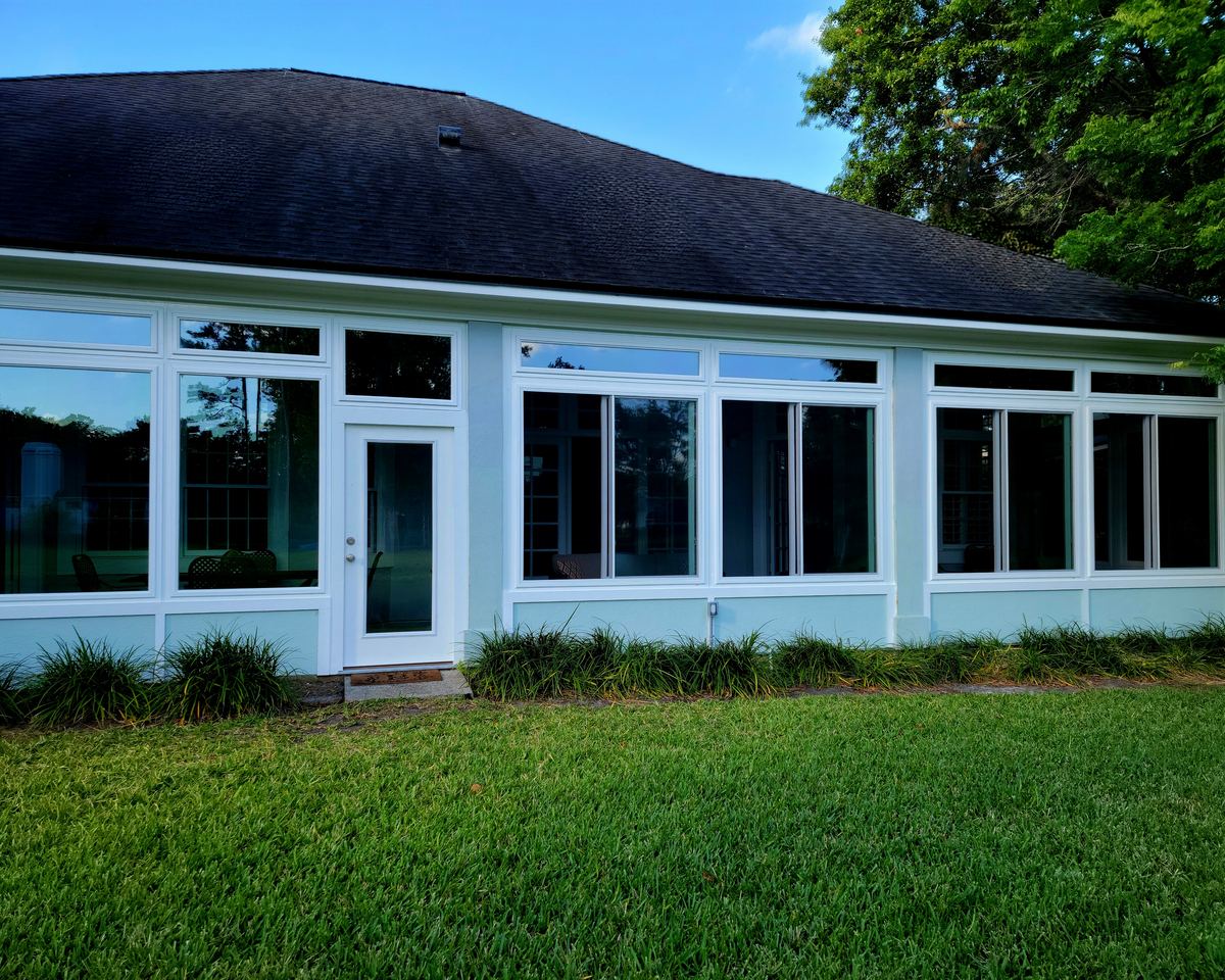 Glass sunroom addition with white-framed windows and transoms completed by Better Home Improvement in Ponte Vedra Beach, FL