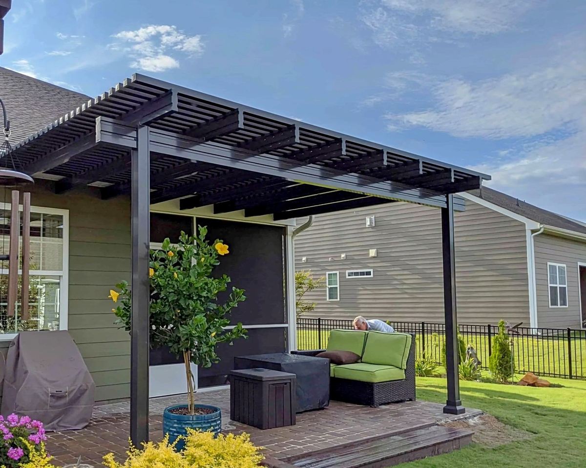 Attached pergola with a slatted top on square posts over a patio, built by Better Home Improvement in St. Augustine, FL