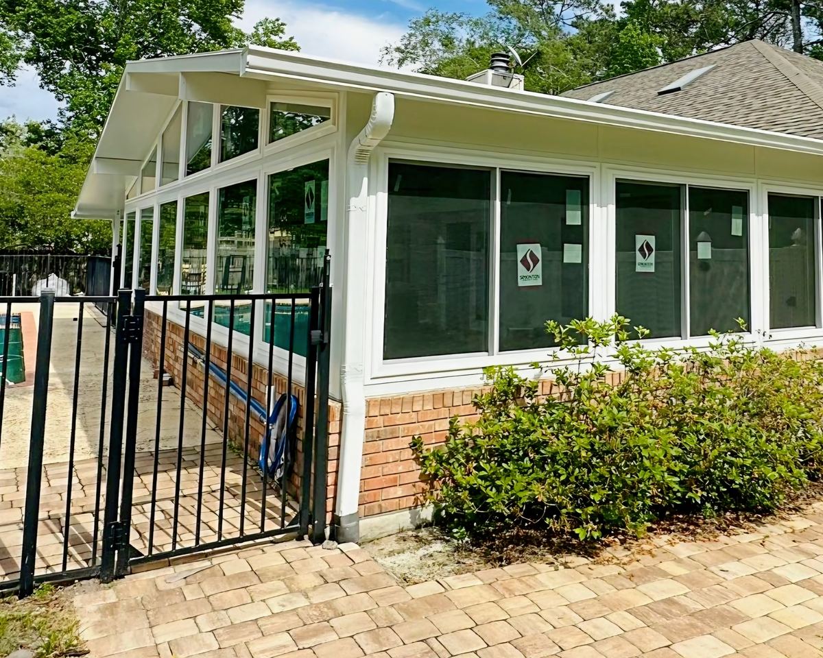 Gable sunroom with a brick kneewall and tall windows with transoms, built by Better Home Improvement in Jacksonville, FL
