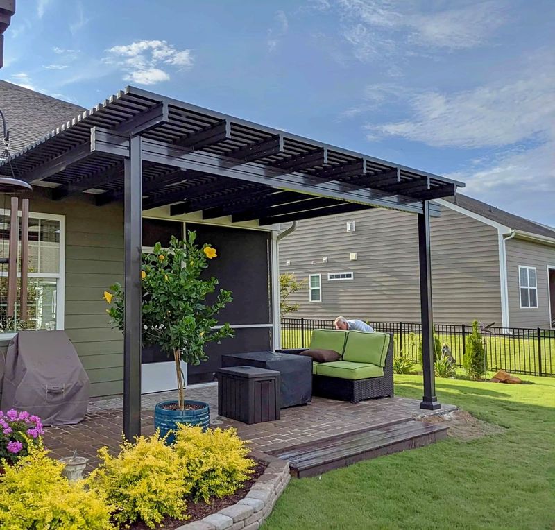 Attached pergola with a slatted top on square posts over a patio, built by Better Home Improvement in St. Augustine, FL